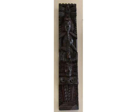 < A carved oak Term figure, 17th century, as a musician playing pipes over a mask and scroll, 60.5cm by 11cm