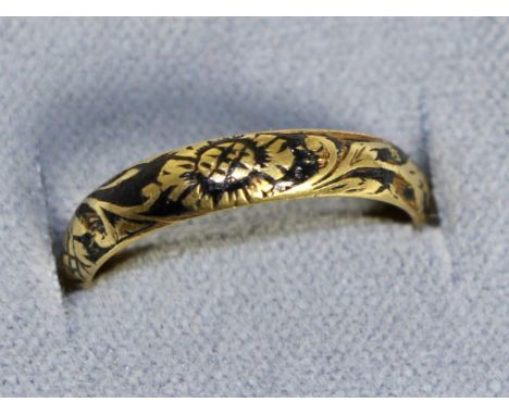 A Queen Anne mourning ring, a black enamel band picked out with a skull and floral scrolls, finger size MThere are losses to 