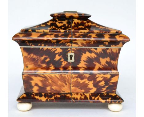 A Regency tortoiseshell tea caddy of shaped rectangular form, containing two lidded compartments on turned ivory feet, 18cm w