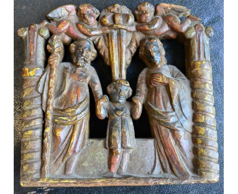 < A Dutch elm carriage panel, circa 1700, carved with the Holy Family below two angels holding a crown flanked by pilasters, 
