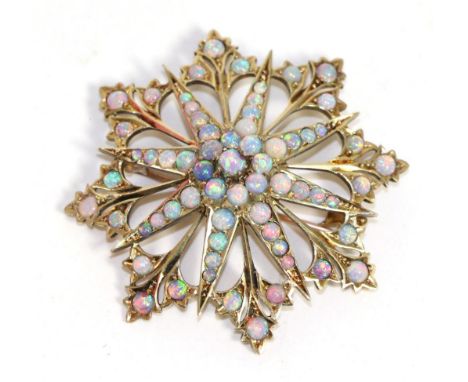 A 15 carat gold opal star brooch/pendant, eight radial arms spaced by trefoil clusters and set throughout with round opals, m