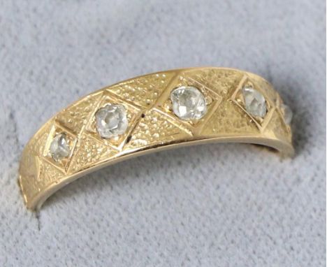 A diamond band ring, five graduated old cut diamonds in kite settings, to a tapering shank with scroll detail, total estimate