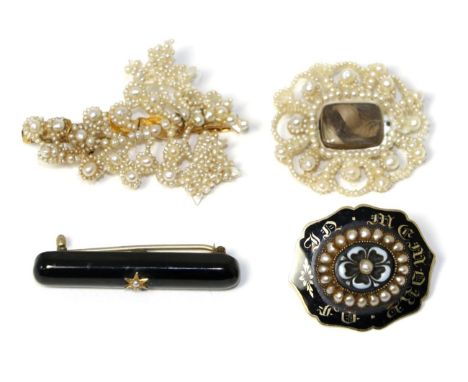 A Victorian carved onyx, seed pearl and enamel mourning brooch, a floral carved onyx set with a seed pearl, within a frame of