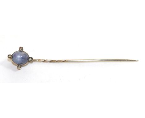 A star sapphire and diamond stick pin, a blue star sapphire on a yellow rubbed over setting within a border of four rose cut 