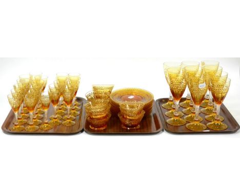 A suite of Stuart amber flashed glass, 20th century, with panel and leaf cut decoration and a twist stems, comprising eleven 