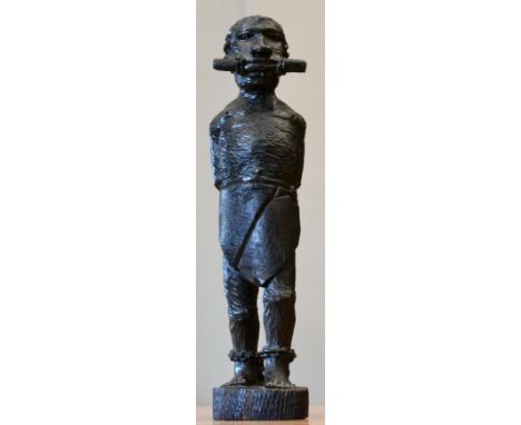 A mid 19th century carved ebony figure of an African slave, standing gagged, his hands chained behind his back and wearing ch