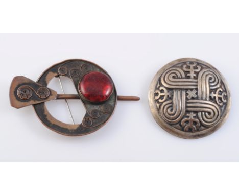 AN ARTS AND CRAFTS COPPER AND RED STONE BROOCH, the circular mount with open detailing set through the centre with a dagger s