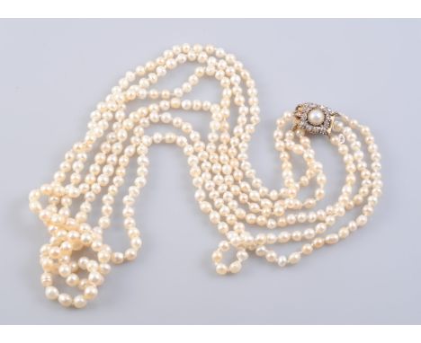 A NATURAL SALTWATER PEARL AND DIAMOND NECKLACE, the slightly graduating natural pearls each strung knotted into three graduat