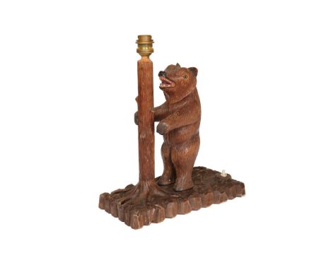 A BLACK FOREST LIMEWOOD TABLE LAMP, with applied carved figure of a standing bear. 32cm high to top of fitting