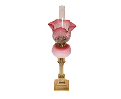 A VICTORIAN BRASS CORINTHIAN COLUMN OIL LAMP, with cranberry tinted reservoir moulded with fruiting vine, etched glass shade,