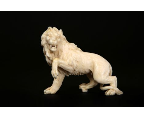 AN IVORY CARVING OF A LION, 19TH CENTURY, carved standing with a raised front paw. 7cm high