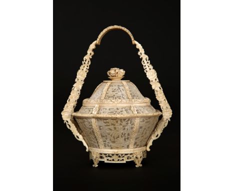 A CHINESE IVORY FRETWORK BASKET AND COVER, CANTON, 19TH CENTURY, with twin section handle, the side panels carved with scenes