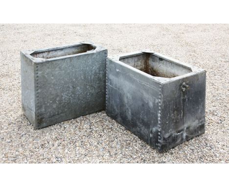 A vintage galvanised water tank of rivetted construction, 62cm wide, 31cm deep, 51cm high, together with a similar tank, 60cm
