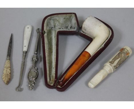 A mixed lot comprising a meerschaum and amber pipe, an ivory cheroot holder carved with an elephant and three button hooks.  