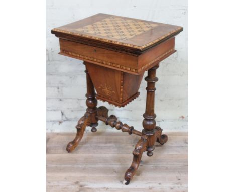 A Victorian walnut games or sewing table with parquetry inlaid chess top swivel and folding over revealing green baize and cr