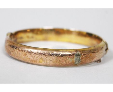 A hallmarked 9ct gold bangle, diam. approx. 5.5cm, wt. 11.7g.  Condition - a number of old repairs, safety chain broken, vari