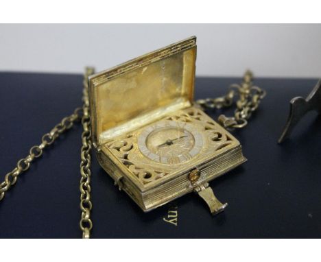 A St James's House Company hallmarked silver gilt pendant watch in the form of a book, with silver gilt chain, silver stand a