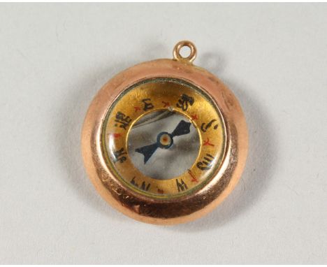 A TINY GOLD COMPASS.