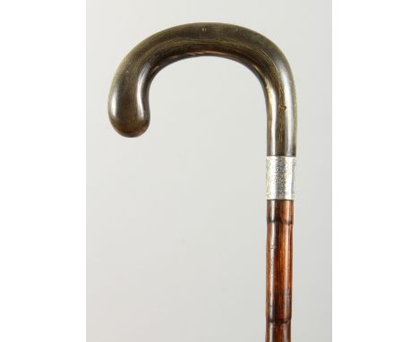 A WALKING STICK with rhino handle and silver band. London 1939.  3ft long.