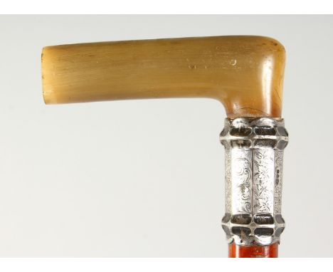 A VICTORIAN WALKING STICK with rhino handle and silver band. London 1894.  2ft 10ins long.