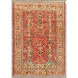 A PERSIAN KASHAN RUG with floral central motifs on a red ground with foliate border. 6ft 6ins x