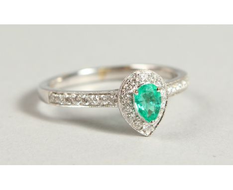 AN 18CT WHITE GOLD LOZENGE SHAPED EMERALD AND DIAMOND RING.