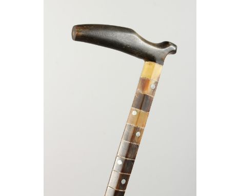 A SEGMENTED STONE WALKING STICK with rhino foot handle. 2ft 10ins long.