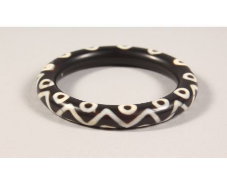 A TIBETAN AGATE BANGLE. 3ins wide.