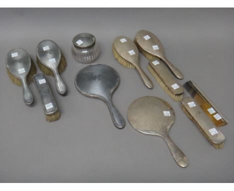 A lady's silver mounted and grey enamelled part dressing set, comprising; a hand mirror, a pair of hairbrushes, a clothes bru