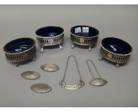 Four George III silver oval salts, each with pierced decoration, within a cast rim and raised on four ball and claw feet, wit