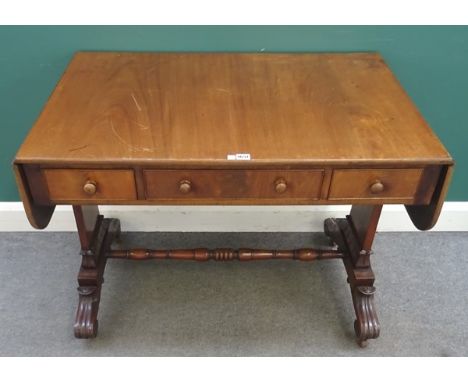 An early Victorian mahogany sofa table, with three frieze drawers on carved trestle end standards and four downswept supports