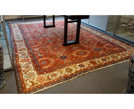 A fereghan carpet, Persian, the madder field with an allover design of flower head medallions, supporting sprays and motifs, 