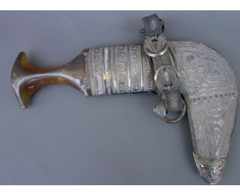 A Middle Eastern jambia with white metal mounts, and a South East Asian white metal opium pipe and pouch, (2).