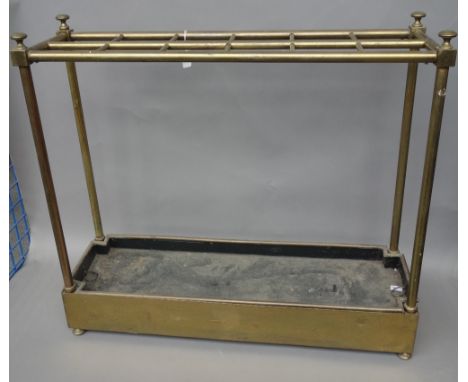 An Edwardian brass tubular twelve division stick stand, of rectangular form, with shaped removable drip tray, 74cm wide x 66c