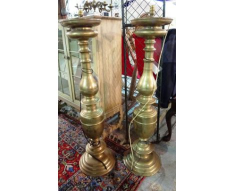 A pair of large 20th century brass altar type candlesticks, converted to lamps, 110cm high and a six light brass ceiling ligh