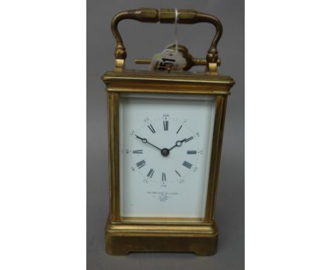 An early 20th century gilt brass cased carriage clock, the white enamel dial detailed 'GOLDSMITH ALLIANCE LTD', with push rep