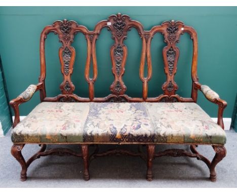 A walnut framed Queen Anne style triple chair back open arm sofa, on carved hoof feet, united by shaped stretcher, 164cm wide