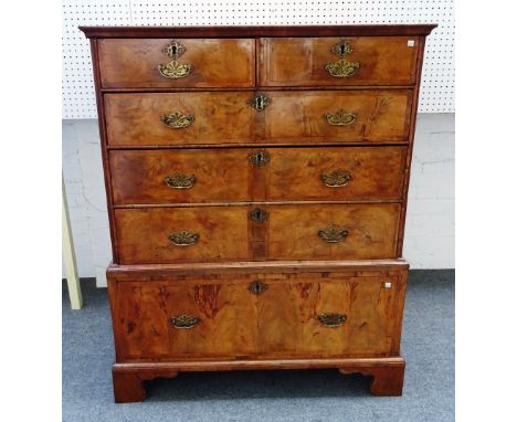 A George I featherbanded walnut chest of two short and three long graduated drawers, on associated single drawer base, on bra
