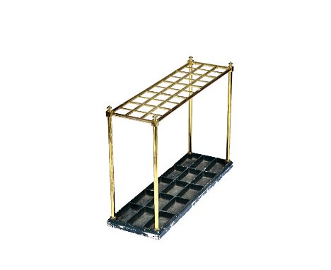 An Edwardian gilt brass tubular thirty division stick stand, on a cast iron painted base, 102cm wide x 71cm high x 33cm deep.