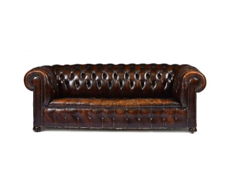 A brown leather button upholstered Chesterfield sofa, with roll over arms, on bun feet, 210cm wide x 68cm high x 90cm deep.  