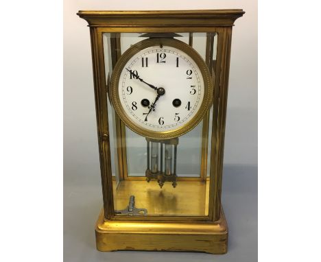 A brass and glass cased mantel clock. Height 30cm.