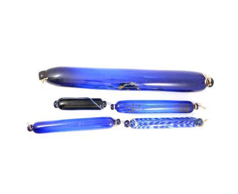 Collection of five 19th century glass frigger rolling pins, four Bristol blue, one brown, the largest with traces of enamel d