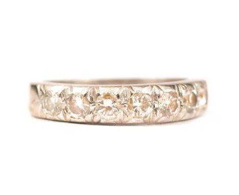 A diamond half eternity ring, seven brilliant cut stones, set in a 4.2mm wide all white metal mount ring size K, shank marked