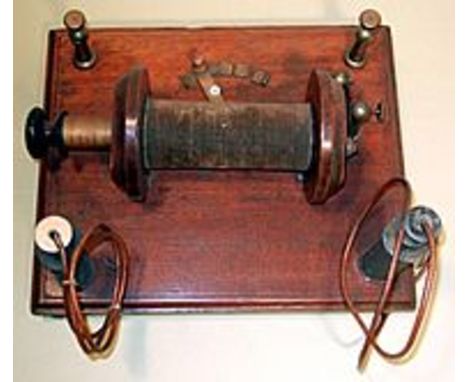 EARLY INDUCED CURRENT COIL, with electro-magnetic interrupter, with graduated draw tube mounted on a polished wooden base.  E