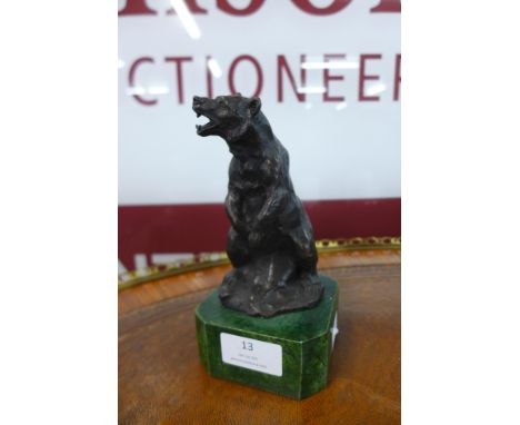 A small figure of a bronze bear, on green marble socle 