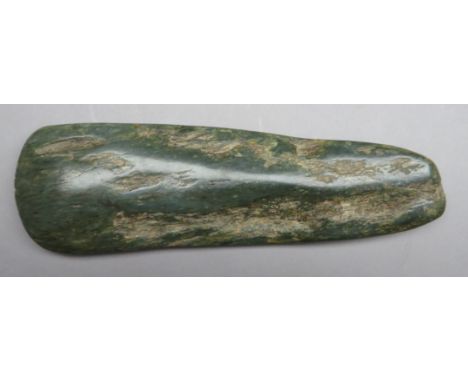 A PACIFIC AXE HEAD, 19TH CENTURY, PROBABLY NEW CALEDONIA of tapering near rectangular form, the surfaces roughly hewn, and sh