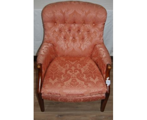 Parker knoll ladies armchair with pink stylised floral pattern and button back.