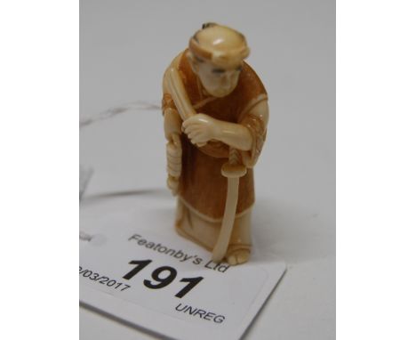 Early 20thC Japanese carved ivory netsuke, a study of a samurai with his long and short swords with character marks inscribed