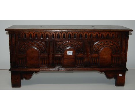 A carved oak 3 panelled blanket box with architectural decoration on bracket feet, 99cm wide, 37cm deep.