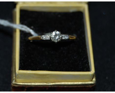 An 18ct gold platinum set diamond ring with centre stone measuring approx 4mm diameter flanked by 2 smaller diamonds either s